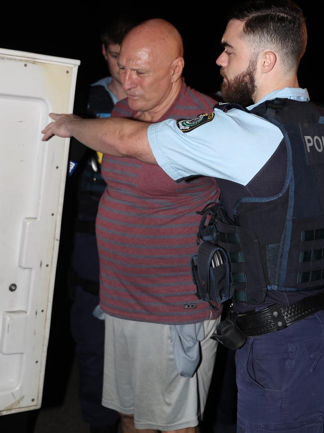 Kevin Theobald is loaded into a police paddy wagon following his arrest. Picture: John Grainger