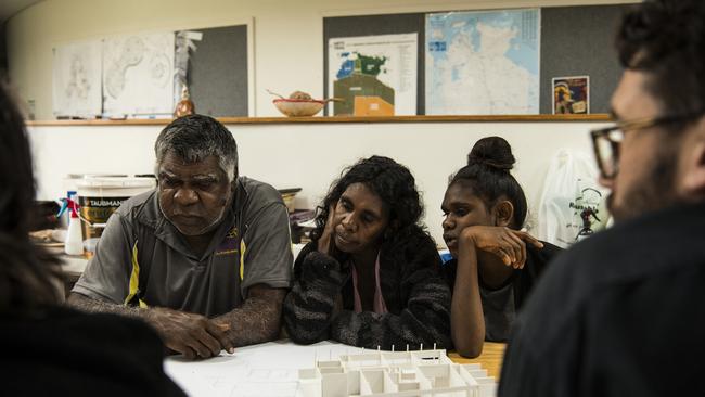 Norm Frank Jupururrla, his wife Serena Morton Nabanunga and daughter look at a cardboard model of a preliminary house designed by Steve Mintern and Simon Robinson (pictured in foreground) from Office, a not-for-profit multidisciplinary design and research practice based in Melbourne, for the Wilya Junta (Standing Strong) Housing Collaboration, inside the Nyinkka Nyunyu Art and Culture Centre in Tennant Creek. Picture: Andrew Quilty