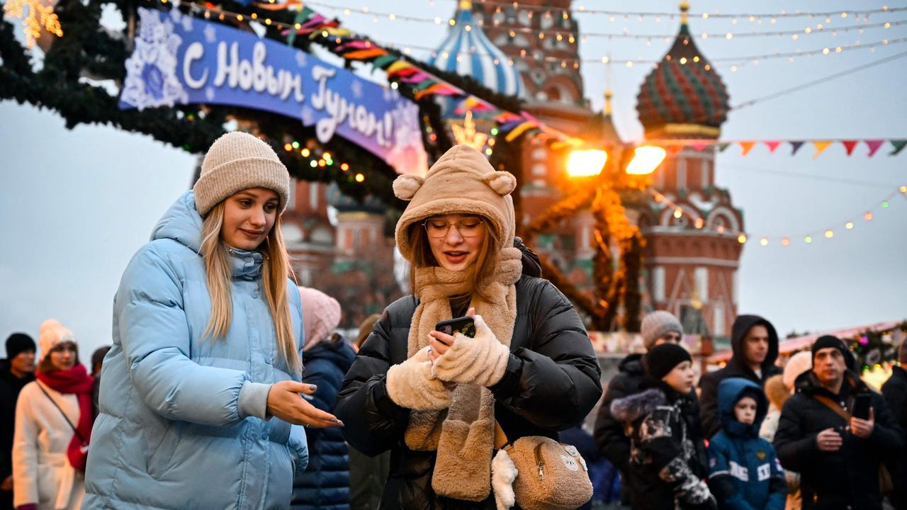 People walk along the Red Square in front of the St. Basil's Cathedral in Moscow on December 31, 2022. Picture: Alexander Nemenov/AFP