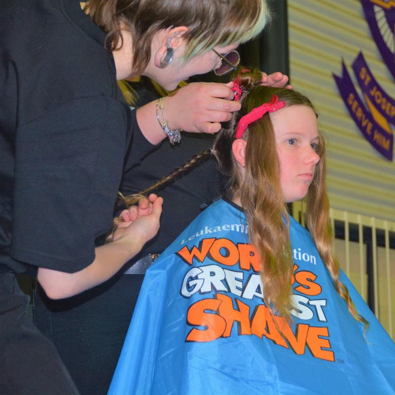 At the St Joseph's College 2023 World's Greatest Shave event is student Meghan Ellis having her cut by hairdresser Caitlin Symes from the Hair Room on Russell. Picture: Rhylea Millar