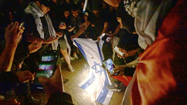 Pro-Palestine protesters burn an Israeli flag during a rally at the Sydney Opera House last October. Picture: NCA NewsWire / Jeremy Piper