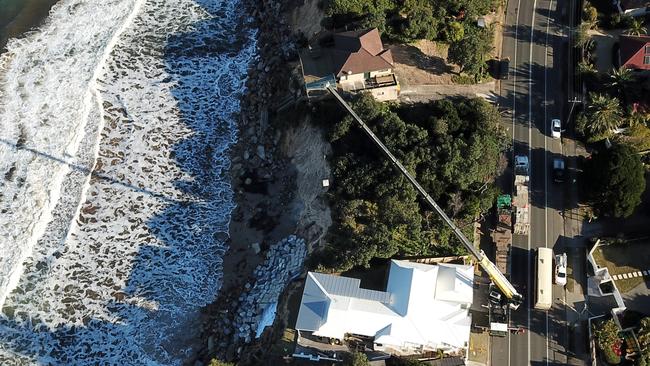 Concrete blocks being craned onto the beach on Ocean View Dr in Wamberal after homes have been evacuated after large waves undermined their foundations over the last week. Picture: Jonathan Ng