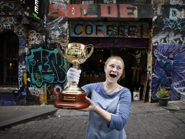 Cafe barista Sarah Bott gets up close and personal with the Melbourne Cup in Hosier Lane. Picture: David Caird