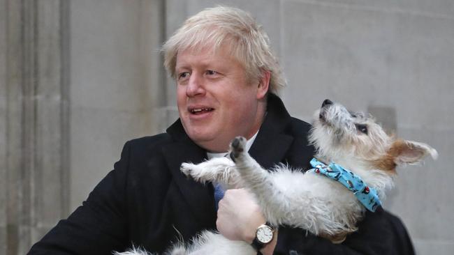 British Prime Minister Boris Johnson holds his dog Dilyn as he leaves after voting in London on Thursday. Picture: AP