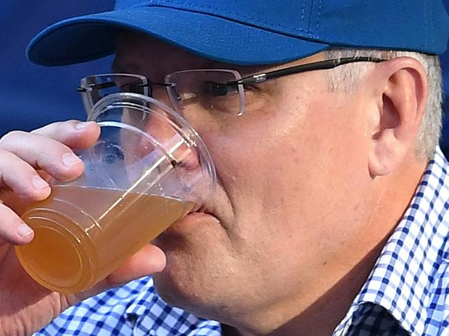 Australian Prime Minister Scott Morrison drinks a beer during the match between Roger Federer of Switzerland and Stefanos Tsitsipas of Greece on day seven of the Australian Open tennis tournament in Melbourne, Sunday, January 20, 2019. (AAP Image/Lukas Coch) NO ARCHIVING, EDITORIAL USE ONLY