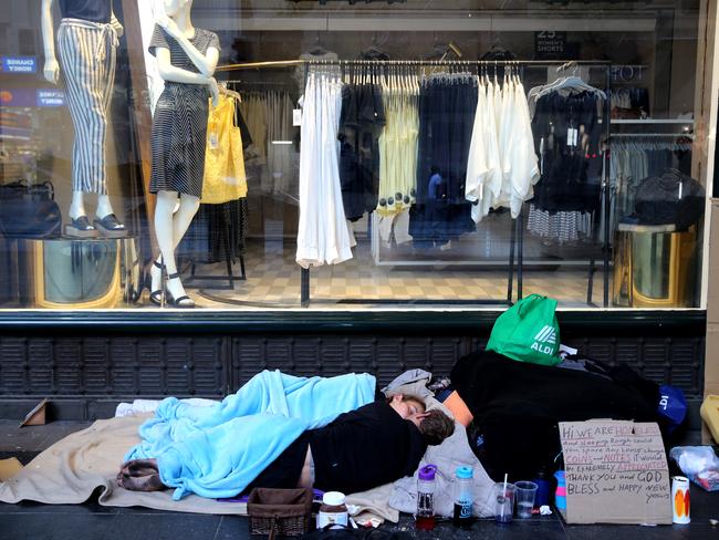 A homeless couple snuggle up outside the QVB on Tuesday morning. Picture: John Grainger