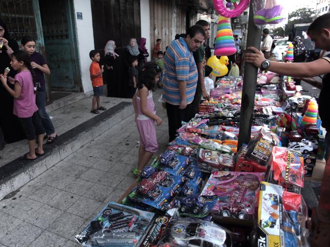 A Palestinian street vendor displays toys for sale as a 72-hour Hamas and Israel cease fire began in Gaza City. AP Photo/Khalil Hamra