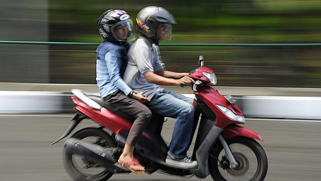 A man and a woman ride a motorbike in Banda Aceh on May 4, 2015. North Aceh district in Indonesia's Aceh has passed legislation banning unmarried men and women from riding together on motorbikes, a lawmaker said on May 4, the latest new Islamic regulation in the conservative province. AFP PHOTO / CHAIDEER MAHYUDDIN