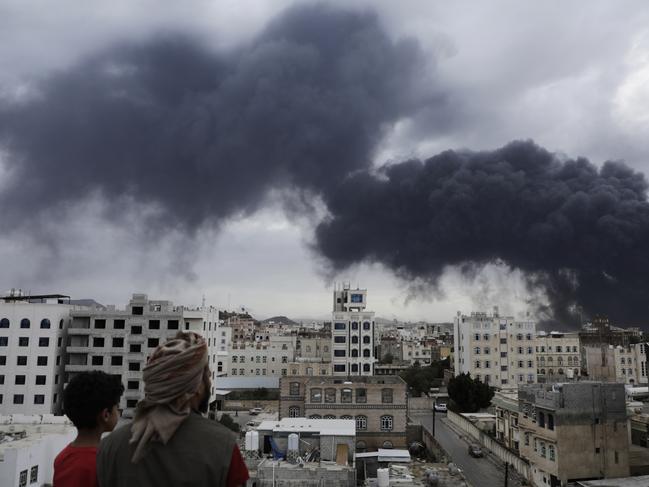 Yemenis watch as smoke billows following Israeli airstrikes targeting a power plant and Sanaa Airport, in Sanaa, Yemen, Tuesday, May 5, 2025. (AP Photo/Osamah Abdulrahman)
