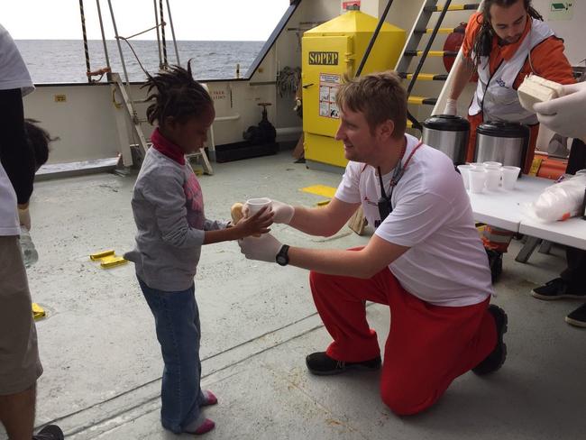 Simon serving food to a rescued refugee girl on MV Aquarius. Picture: Kevin McElvaney