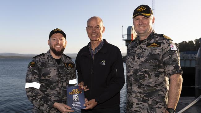 Commanding Officer of HMAS Sheean, Commander Tim Markusson, with the Hon. Guy Barnett, MP, Tasmanian Minister for Veteran Affairs, as he presents a copy of his book 'Our Heroes' to Leading Seaman Acoustic Warfare Analyst Alexander Howard (left) in Launceston, Tasmania. Picture: LS Daniel Goodman/ Australian Defence Force