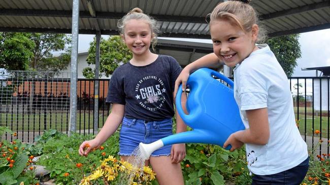 GREEN THUMBS: Mia Bouris, 10, and Laura Bradford, 10, tending to Brightwater State School's vegie garden. Picture: Eden Boyd
