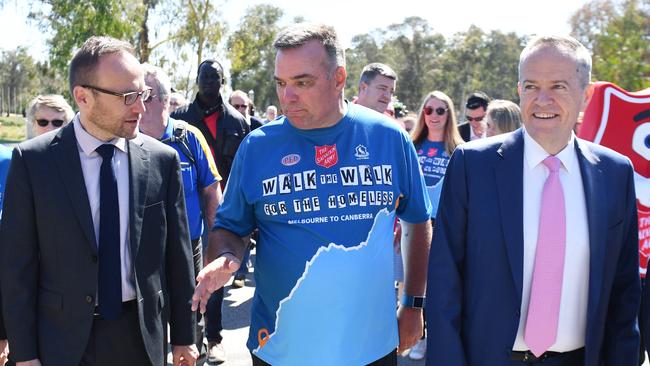 Salvation Army leader Brendan Nottle, centre, finishes his walk from Melbourne to Canberra with  Greens Member for Melbourne Adam Bandt, left, and Leader of the Opposition Bill Shorten, right, at Parliament House in Canberra, today.