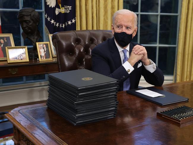 Ready to get to work. US President Joe Biden prepares to sign a series of executive orders at the Resolute Desk in the Oval Office just hours after his inauguration. Picture: Getty Images