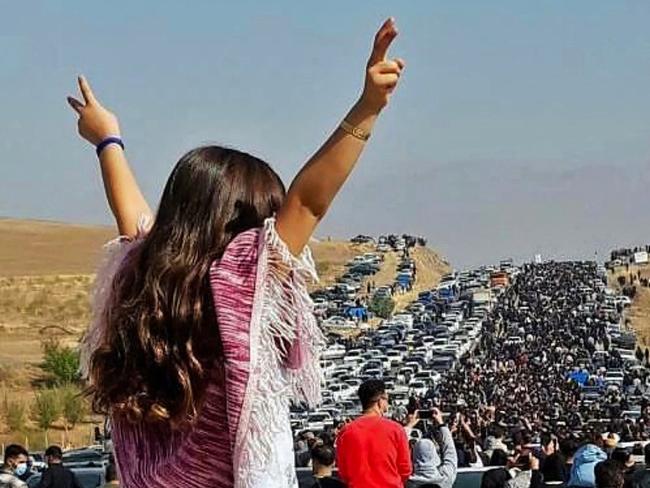 This UGC image posted on Twitter reportedly on October 26, 2022 shows an unveiled woman standing on top of a vehicle as thousands make their way towards Aichi cemetery in Saqez, Mahsa Amini's home town in the western Iranian province of Kurdistan, to mark 40 days since her death, defying heightened security measures as part of a bloody crackdown on women-led protests. - A wave of unrest has rocked Iran since 22-year-old Amini died on September 16 following her arrest by the morality police in Tehran for allegedly breaching the country's strict rules on hijab headscarves and modest clothing. (Photo by UGC / AFP) / Israel OUT - NO Resale / XGTY/RESTRICTED TO EDITORIAL USE - MANDATORY CREDIT AFP -  SOURCE: ANONYMOUS - NO MARKETING - NO ADVERTISING CAMPAIGNS - NO INTERNET - DISTRIBUTED AS A SERVICE TO CLIENTS - NO RESALE - NO ARCHIVE -NO ACCESS ISRAEL MEDIA/PERSIAN LANGUAGE TV STATIONS OUTSIDE IRAN/ STRICTLY NO ACCESS BBC PERSIAN/ VOA PERSIAN/ MANOTO-1 TV/ IRAN INTERNATIONAL/RADIO FARDA - AFP IS NOT RESPONSIBLE FOR ANY DIGITAL ALTERATIONS TO THE PICTURE'S EDITORIAL CONTENT / ALTERNATIVE CROP