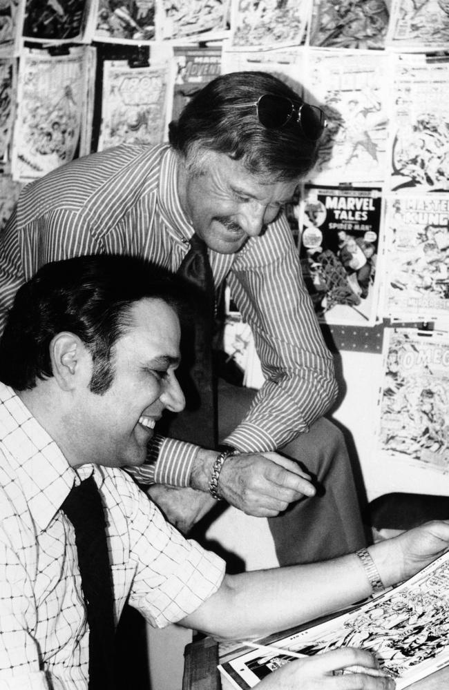 In this 1976 photo, Stan Lee, standing, discusses a Spider-Man comic book cover with artist John Romita at Marvel headquarters in New York. Picture: AP Photo/File