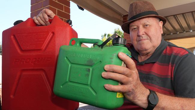 Michael Dunn with two petrol containers, a 20 litre and a 5 litre, he filled then found he was charged for almost 30 litres. Picture: Dean Martin