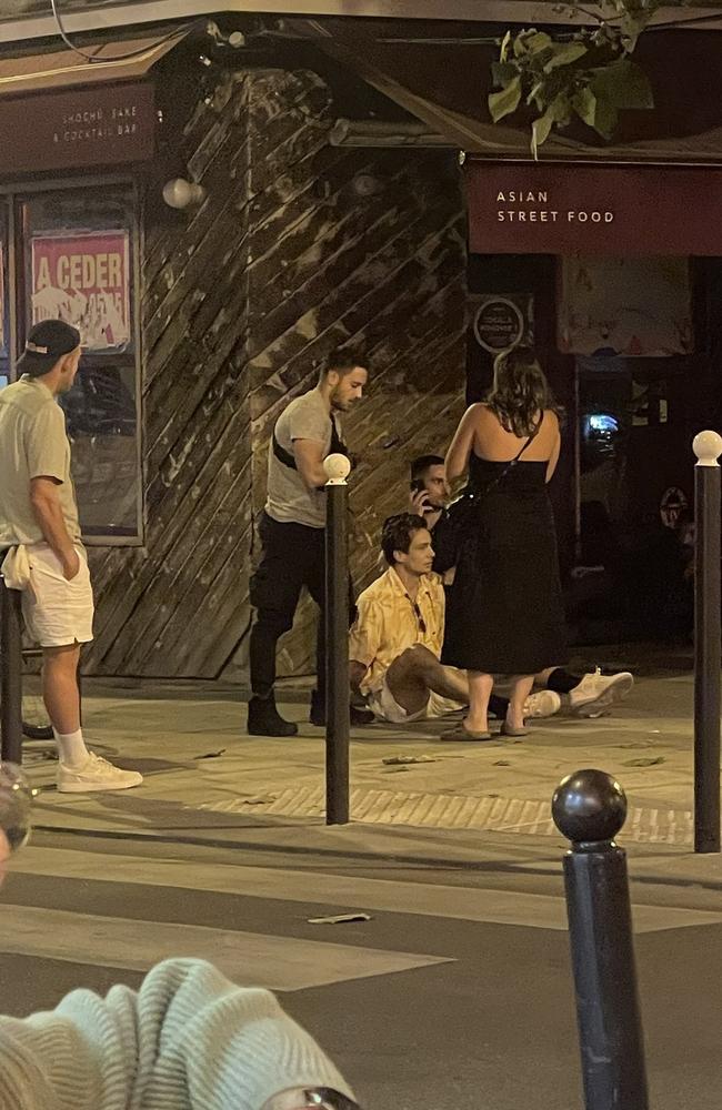 Australian mens hockey player Tom Craig sits on the footpath in Paris after being arrested for allegedly buying cocaine on Tuesday night.