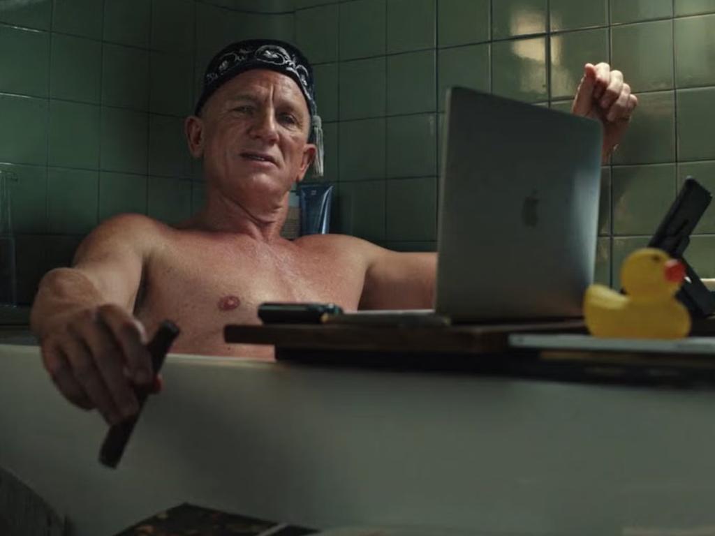 Nice ducky, Daniel ... the 007 actor in enjoys a bath and a browse through Cain’s Jawbone in Glass Onion. Picture: Netflix