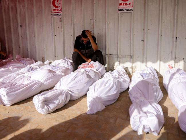 A Palestinian man reacts as he mourns among the bodies of victims of Israeli strikes on Jabalia, at the Indonesian Hospital in Beit Lahia in the northern Gaza Strip on May 14. Picture: AFP