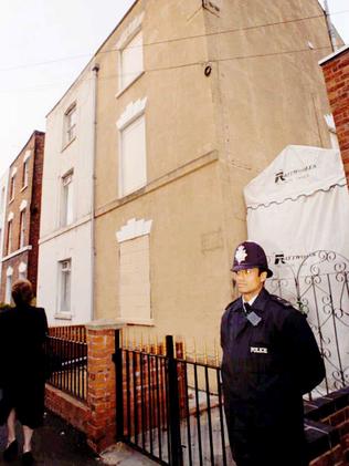 A police officer stands guard at 25 Cromwell St, Gloucester. The house has since been demolished.