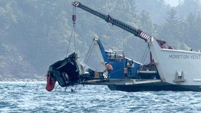 A barge anchored at the site where a MRH 90 military helicopter crashed, lifts out the tail section on Saturday. Picture: Michaela Harlow