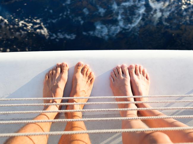 Closeup of couples feet on a yacht.