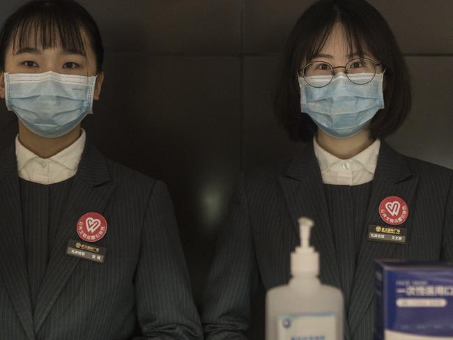 WUHAN, CHINA - MARCH 30: (CHINA OUT) Staff members wear face masks and stand at an in store service center inside Wuhan international plaza on March 30, 2020 in Hubei Province, China. Wuhan, the central Chinese city where the coronavirus (COVID-19) first emerged last year, will lift the lockdown on April 8, local media reported. (Photo by Getty Images)