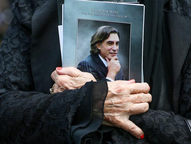 A mourner carries a booklet from the funeral of murdered lawyer Joe Acquaro. Picture: Ian Currie