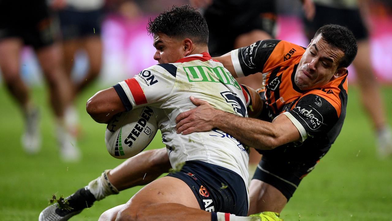 Latrell Mitchell of the Roosters is tackled by Corey Thompson of the Tigers