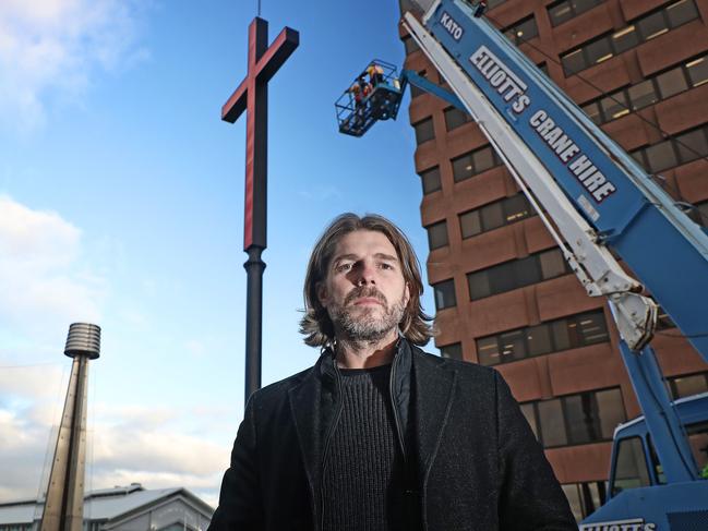 Dark Mofo creative director Leigh Carmichael with one of the crosses being installed on Hobart’s waterfront this week. Picture: LUKE BOWDEN