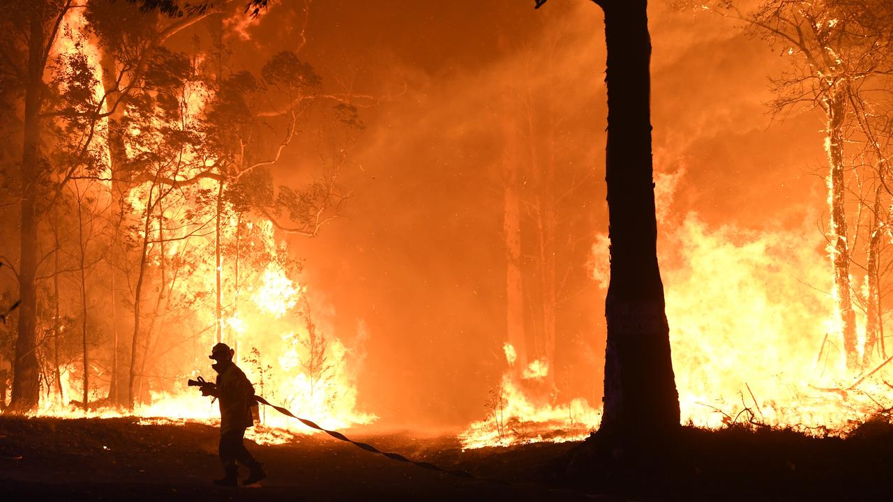 RFS, NSW Fire and Rescue, NPWS officers and local residents fight a bushfire encroaching on properties near Termeil on the Princes Highway between Batemans Bay and Ulladulla south of Sydney, Tuesday, December, 3, 2019. Picture: AAP/Dean Lewins.
