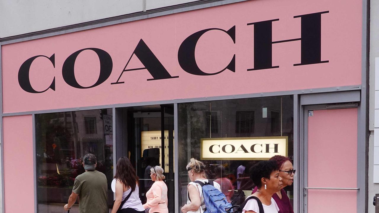 Pedestrians walk past a Coach store. Picture: AFP