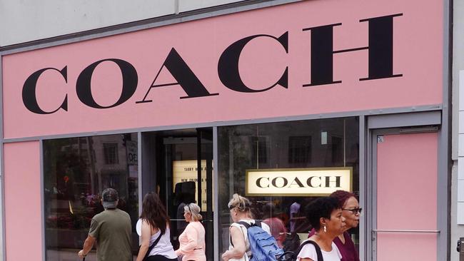 Pedestrians walk past a Coach store. Picture: AFP