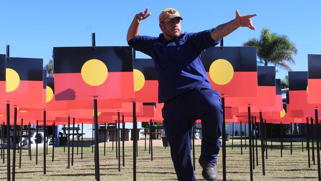 Noa Fletcher in front of 250 Aboriginal flags.