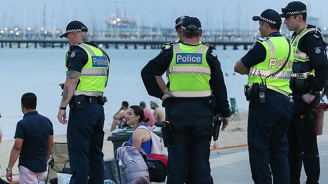 Police keep an eye on the action at St Kilda foreshore. Picture: Ian Currie