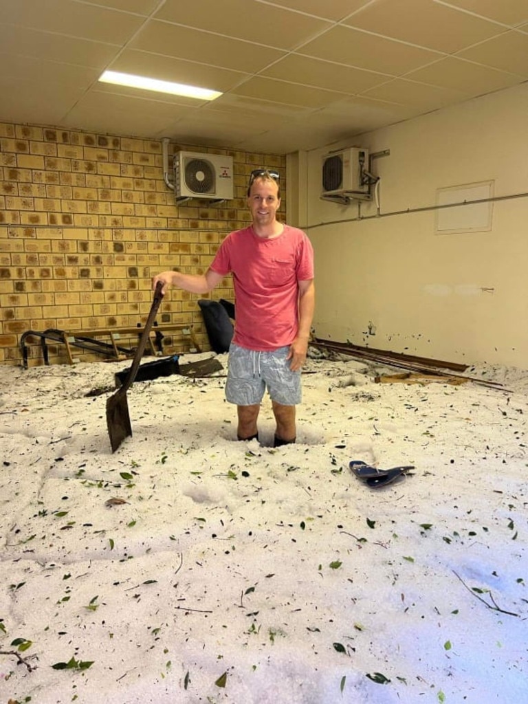 Dan Heaton cleans up hail after the overnight storm.