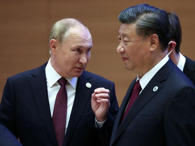 Russian President Vladimir Putin speaks to China's President Xi Jinping during the Shanghai Cooperation Organisation (SCO) leaders' summit in Samarkand on September 16, 2022. (Photo by Sergei BOBYLYOV / SPUTNIK / AFP)