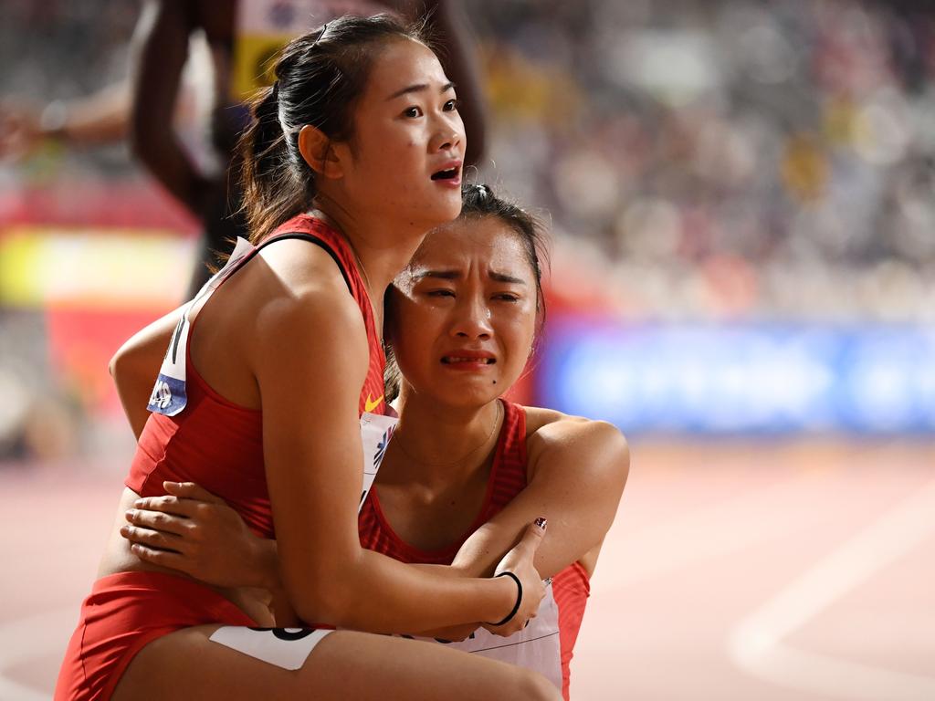 China's Liang Xiaojing comforts teammate Ge Manqi after the Women's 4x100m relay final.