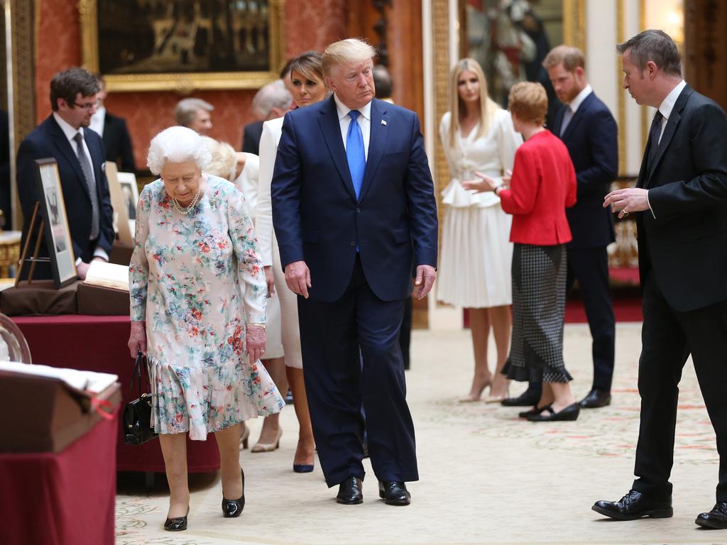 Queen Elizabeth II and President Donald Trump at Buckingham Palace with Harry in the background.