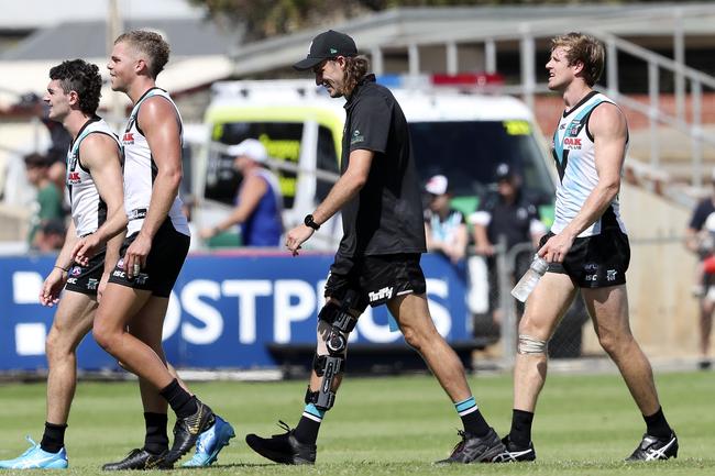 Power’s Jarrod Lienert walks off after the win against Noprth Melbourne with his leg heavily braced at Alberton Oval. Picture Sarah Reed