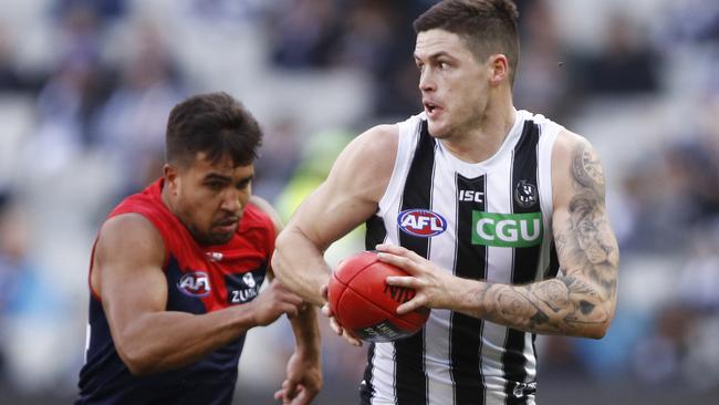 Jack Crisp of the Magpies runs with the ball.