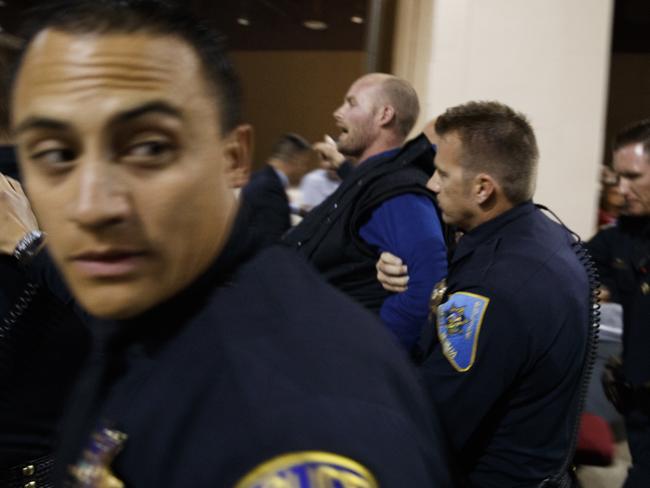 Austyn Crites is escorted out by law enforcement officers moments after Donald Trump was rushed offstage by Secret Service agents. Picture: AP/ Evan Vucci