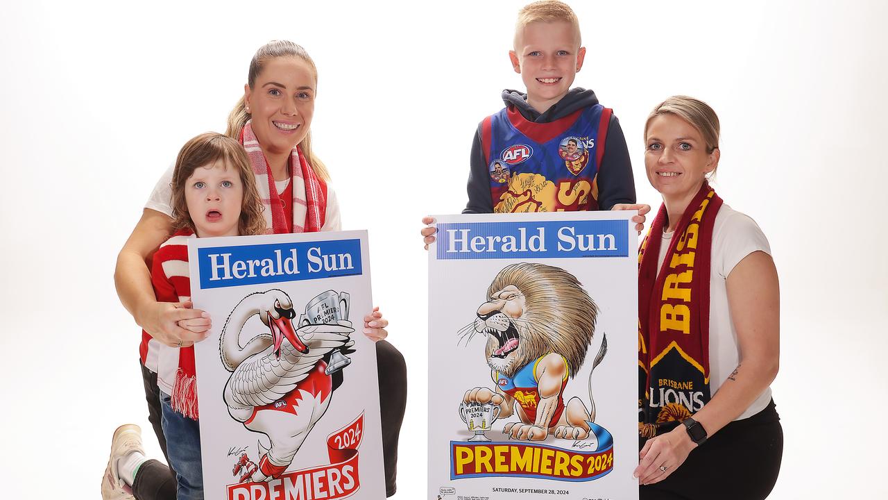 Dedicated footy fans hold their team’s poster – which one will be victorious? Picture: Ian Currie