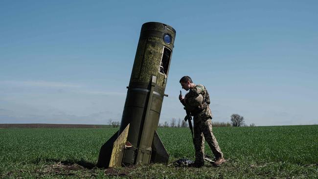 A Ukrainian serviceman looks at a Russian ballistic missile's booster stage that fell in a field in Bohodarove, eastern Ukraine, amid the Russian invasion of Ukraine. Picture: AFP