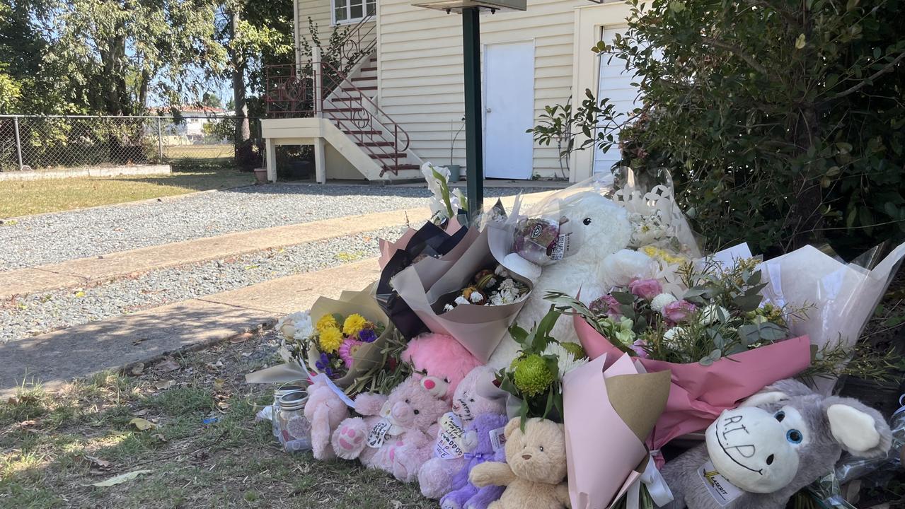 Tributes of flowers and toys sit at the mailbox of the Bean St in Rockhampton home where Tayla and baby Murphy lived.