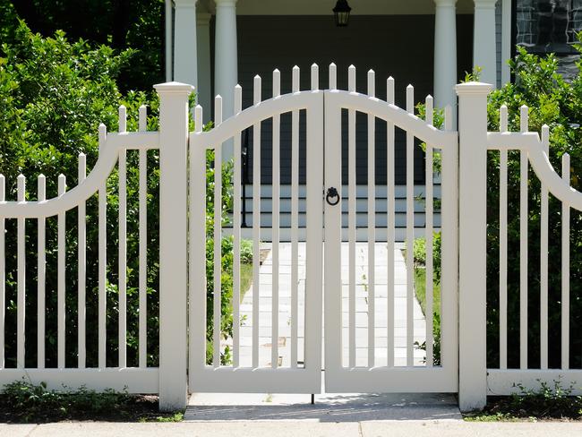 Front gate and white fence on elegant house entrance