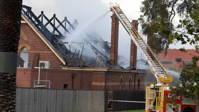 Crews blast hoses at the roof of the building. Picture: Andrew Henshaw