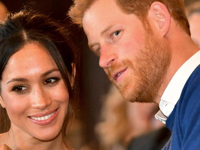 CARDIFF, WALES - JANUARY 18:  Prince Harry whispers to Meghan Markle as they watch a dance performance by Jukebox Collective in the banqueting hall during a visit to Cardiff Castle on January 18, 2018 in Cardiff, Wales. (Photo by Ben Birchall - WPA Pool / Getty Images)