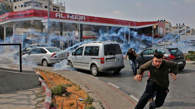 Palestinians run away from tear gas shot at them by Israeli forces during a protest in Ramallah, in the occupied West Bank. Picture: AFP